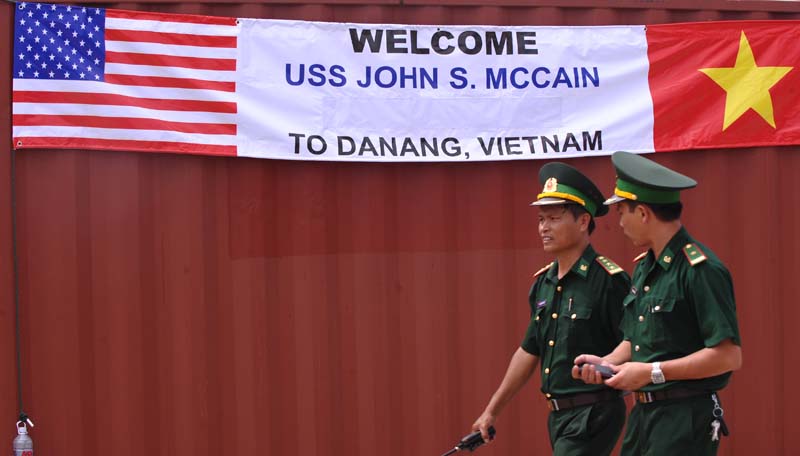 Two Vietnamese border-guard officers walk past a banner welcoming the port call by the US destoryer USS John S. McCain at Tien Sa port in the central costal city of Danang on August 10, 2010. (HOANG DINH NAM/AFP/Getty Images)