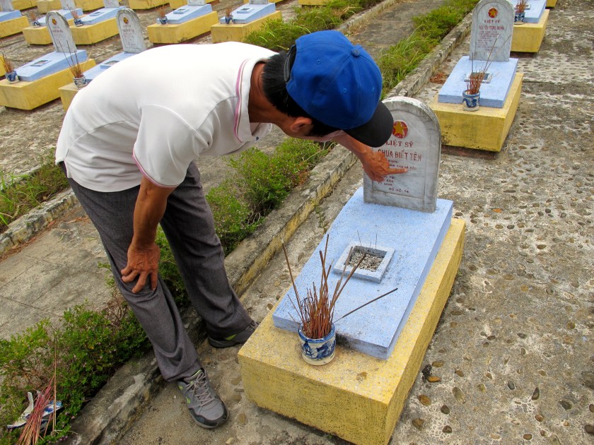 Tran Hoa, my guide, shows me one of the hundreds of graves for unknown soldiers at the Route 9 Cemetery. (Photo by Nissa Rhee, June 2014)