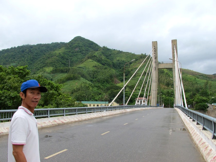 Hoa Tran, my guide, shows me the Dakrong Bridge that   crosses the Han River. (Photo by Nissa Rhee, June 2014)