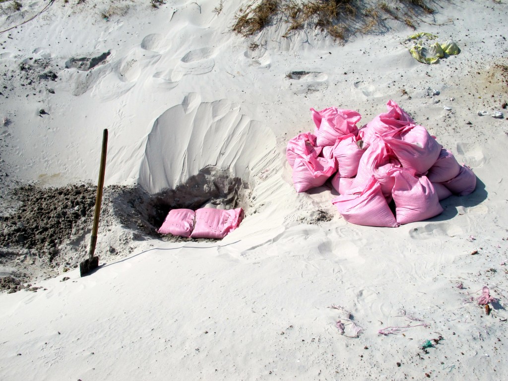 Sandbags are then placed on top of the UXO to prevent debris from flying when they are detonated. (Photo by Nissa Rhee, June 2014)