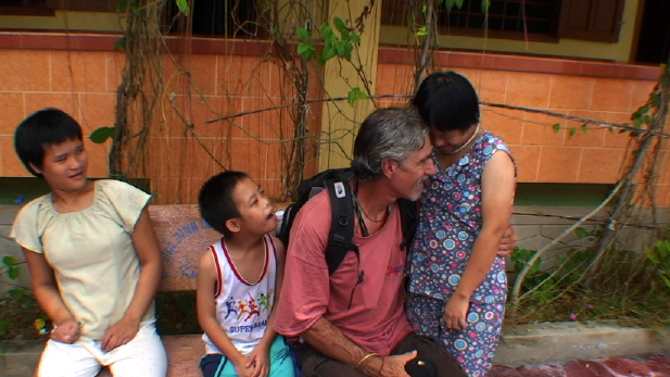 Joe Sciacca embraces two children he helps in Vietnam. (Photo from Ordinary Joe movie site)
